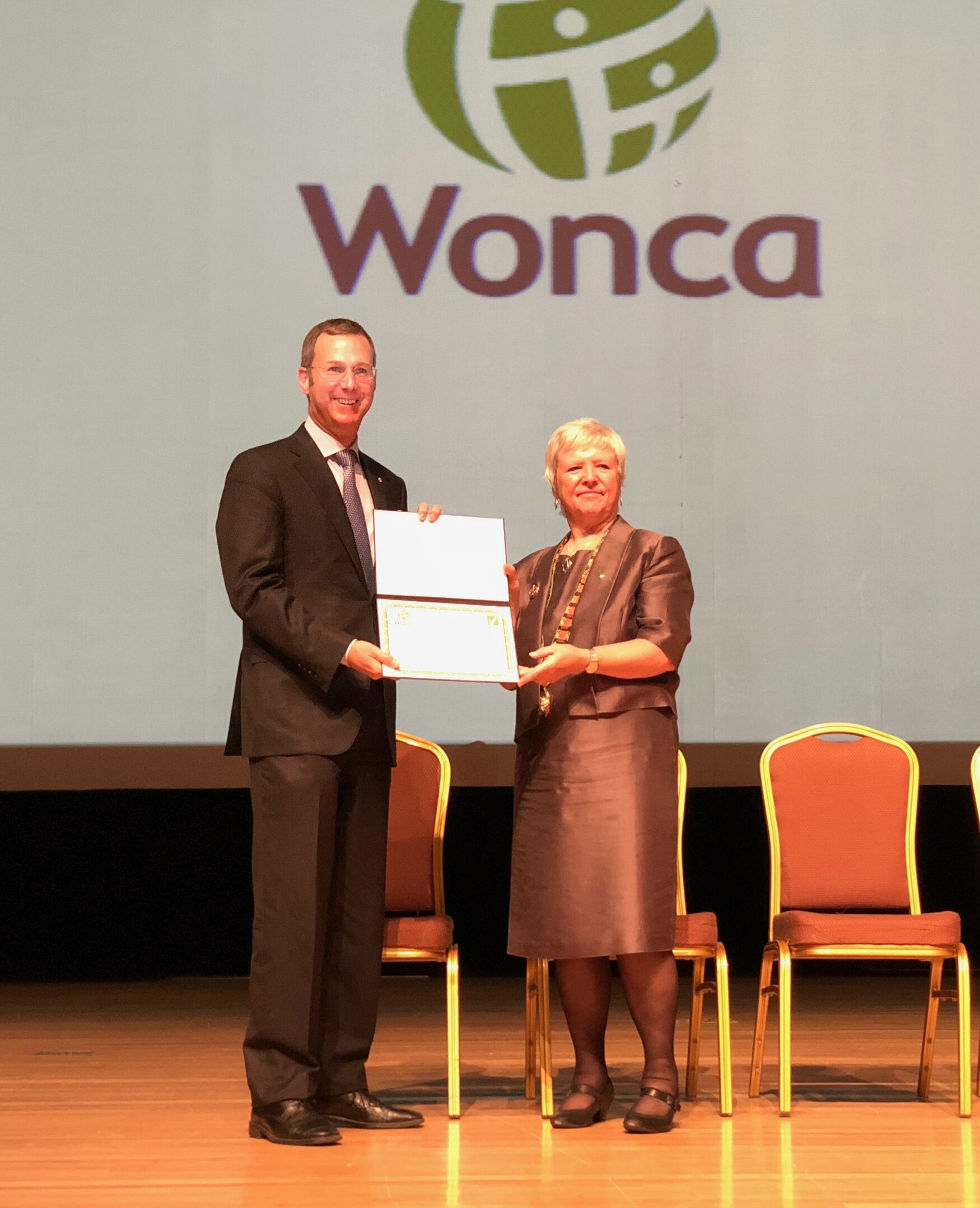 WONCA president Amanda Howe presenting DFCM Chair Dr. Michael Kidd with DFCM's WONCA accreditation certificate to DFCM