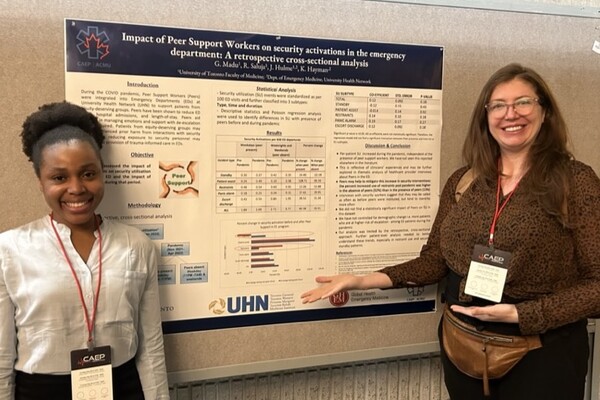 Two individuals presenting an emergency medicine research poster