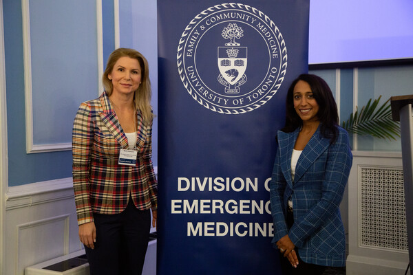 Dr. Maria Ivankovic and Dr. Meeta Patel by a Division of Emergency Medicine poster