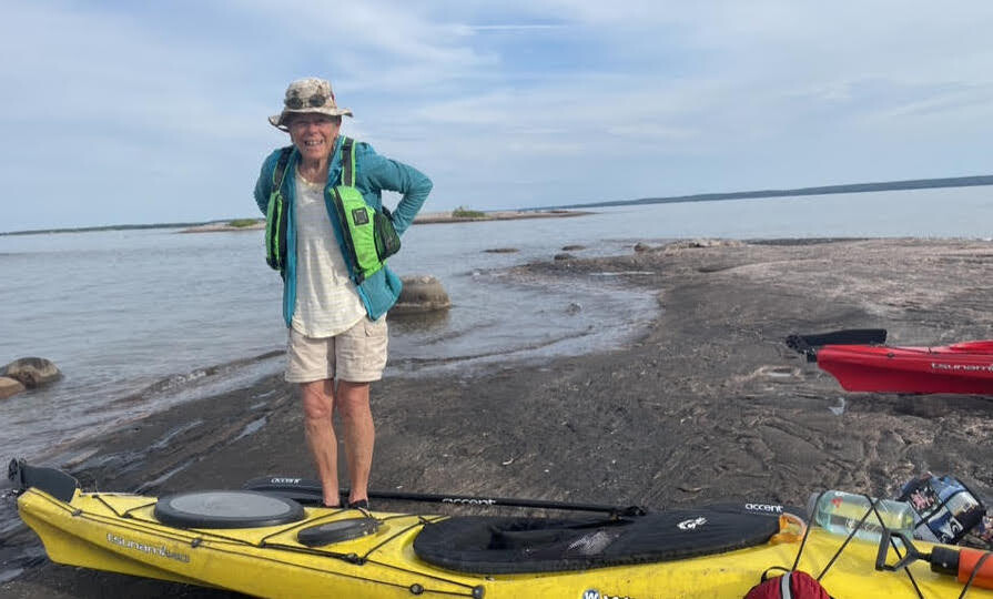 Dr. Jean Marmoreo on a beach with a yellow canoe